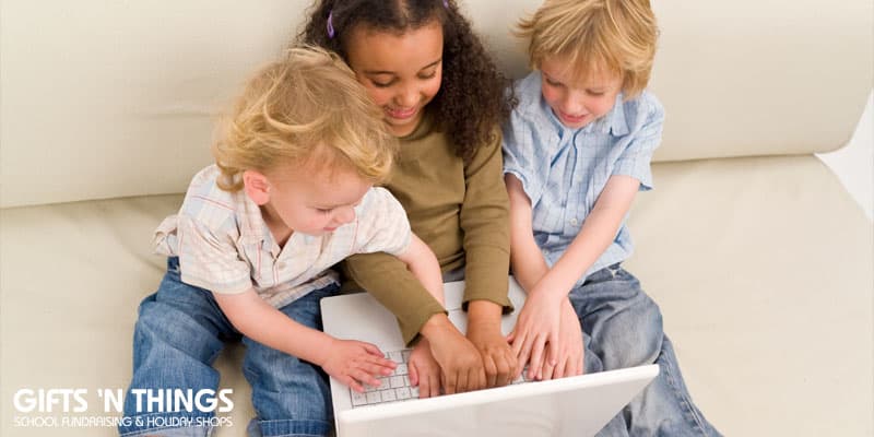three kids playing on a laptop computer