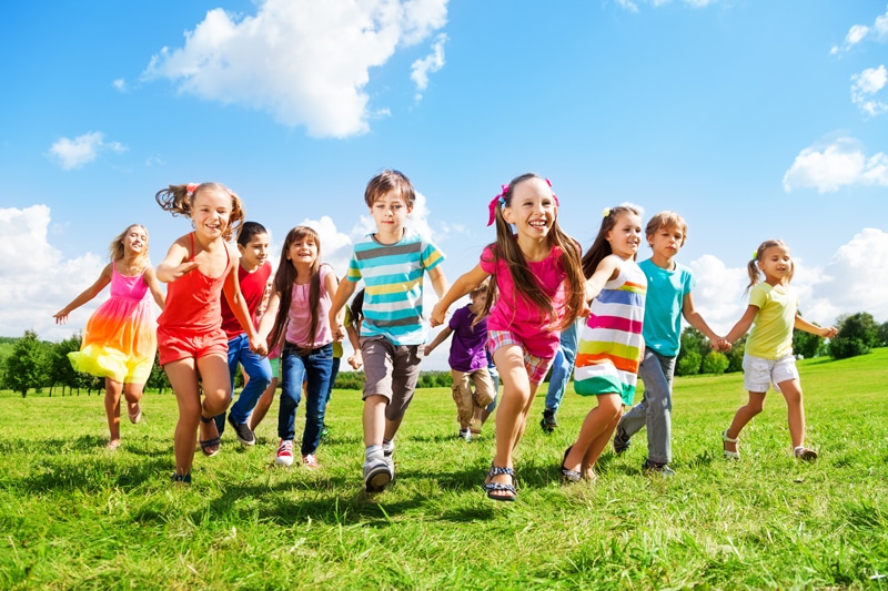 Children Running Through A Field In The Spring