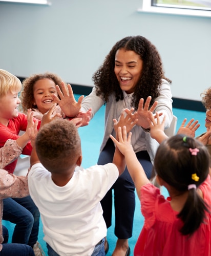 Teacher With Kids Smiling And High Fiving